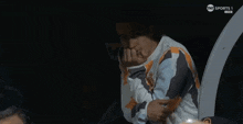 a man sitting in a dark room watching a tnt sports 1 live match