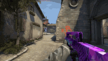 a person holding a purple gun in front of a brick wall