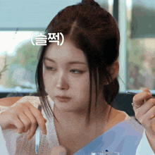 a woman is holding a knife and fork with a foreign language sticker above her head