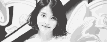 a black and white photo of a girl with short hair looking at the camera .