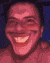 a close up of a man 's face with a huge smile on it .