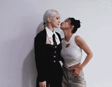 two women standing next to each other and one is kissing the other