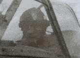 a man in a helmet and goggles is smoking a cigarette in a plane .