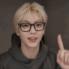 a yellow smiley face wearing glasses and giving a rock sign
