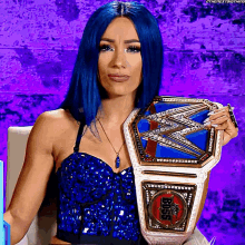 a woman with blue hair is holding a world heavyweight wrestling championship