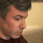 a man with gray hair looks down at something
