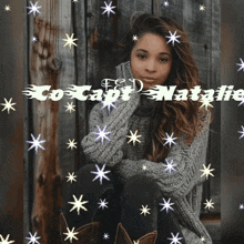 a woman in a grey sweater is surrounded by stars and the name natalie