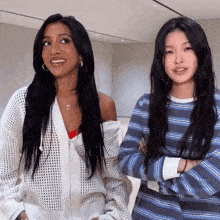 two women are standing next to each other with their arms crossed and one has a necklace with the letter k on it