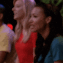 a blurry picture of a woman in a red shirt and another woman in a blue shirt