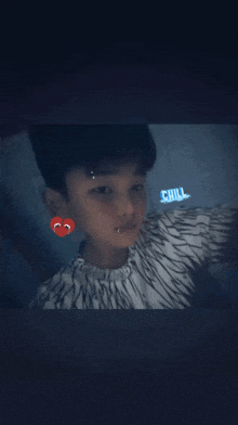 a young boy taking a selfie with the word chill written on his chest