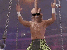a man wearing a mask and sunglasses is dancing in front of a sign that says wwe