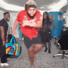 a man in a red shirt is running with a aldi bag