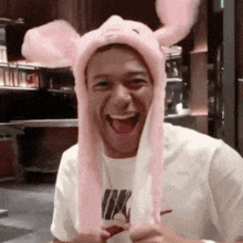 a man wearing a pink hat with bunny ears and a nike shirt