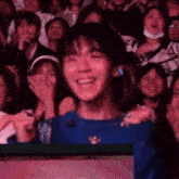 a group of people are sitting in a stadium watching a show and laughing .