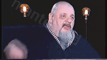 a man with a beard is holding two light bulbs in front of him