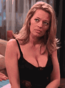 a woman in a black tank top has a very large breast