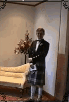 a man in a kilt is standing in a room