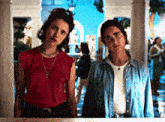 two women are standing next to each other and one of them is wearing a red shirt that says " i love you "