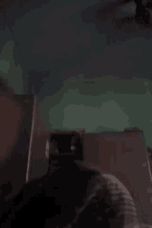 a person is standing in a dark room next to a green wall