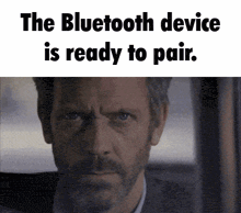a man with a beard is looking out a window and says the bluetooth device is ready to pair