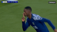 a soccer player in a blue shirt is running on a field .