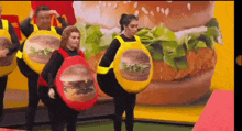 a group of people are dressed up as hamburgers in front of a mcdonald 's advertisement .