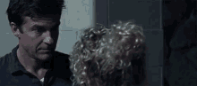 a man and woman are looking at each other in a dark room .