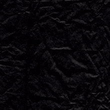 a crumpled piece of black paper with a purple circle in the middle
