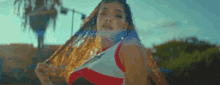 a woman with long hair is wearing a red white and black top
