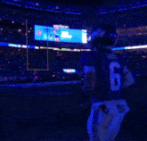 a new york giants football player stands in front of the metlife stadium