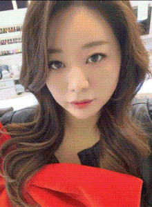 a woman with long brown hair is wearing a red shirt