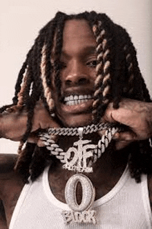 a close up of a man with dreadlocks wearing a necklace .