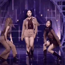 a woman in a fringed jacket and shorts is dancing with two other women