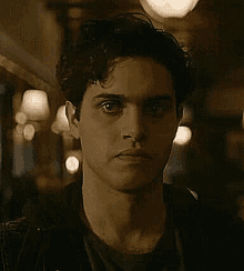 a close up of a man 's face with a serious look on his face in a dark room .