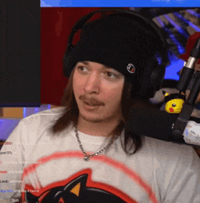 a man wearing headphones and a beanie with a j on it