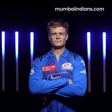 a man with his arms crossed is wearing a blue shirt that says indians