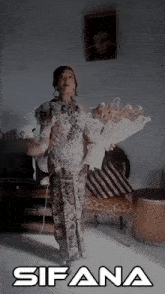 a woman is holding a bouquet of flowers and the name sifana is on the bottom right
