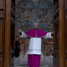 a priest in a purple cape stands in front of a painting
