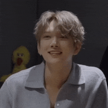 a close up of a person 's face with a yellow stuffed duck in the background