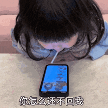 a girl is drinking from a straw while looking at a phone