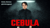 a man in a black jacket is standing in front of a poster that says cebula