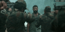 a man with a beard is surrounded by soldiers and the words pranay varna are on the bottom