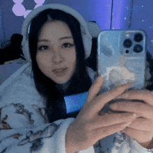 a woman wearing headphones is taking a selfie