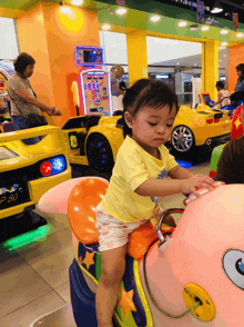 a little girl sits on a ride that says p50 on the back