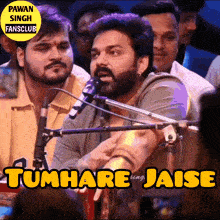 a man singing into a microphone with the words tumhare jaise behind him