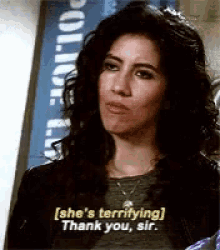 a woman is standing in front of a sign that says ' she 's terrifying thank you sir ' .