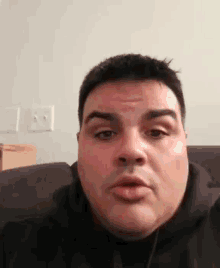 a man is sitting on a couch with his mouth open and making a funny face .