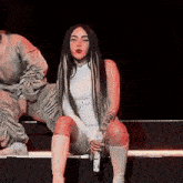 a woman is sitting on a bench holding a microphone .