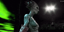 a statue of a woman with a crown on her head stands in a dark room