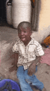 a young boy is sitting on the ground with his mouth open .
